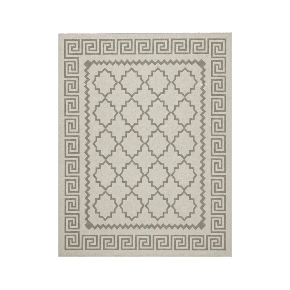 Rectangular grey polyester rug with a geometric pattern and Greek key border on a wooden outdoor deck with patio furniture.
