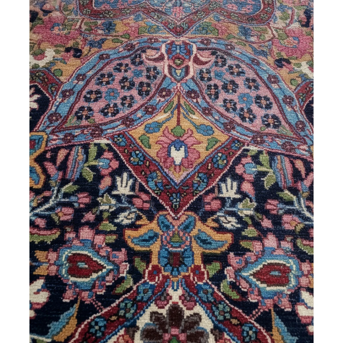 Close-up of intricate floral motifs and curvilinear elements in the multi-color rug