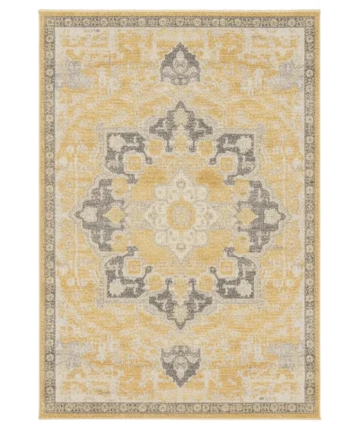 Angled view of a rectangular modern contemporary rug with a distressed yellow and gray abstract pattern on a gray floor.